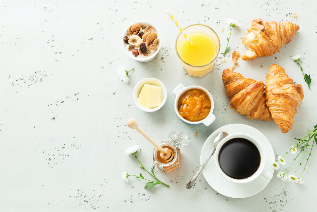 Quick and balanced continental breakfast. Coffee, orange juice, croissants, jam, honey and flowers.
