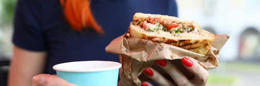 Close-up of woman holding delicious sandwich. Break for quick lunch. 