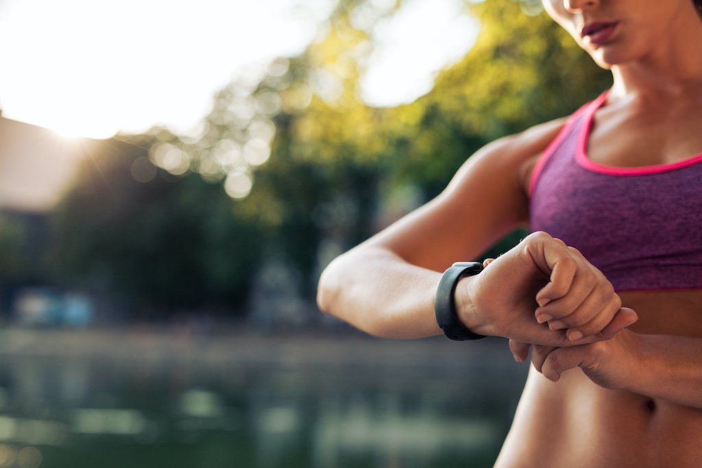 Woman setting up the fitness smart watch for running. Sportswoman checking watch device.