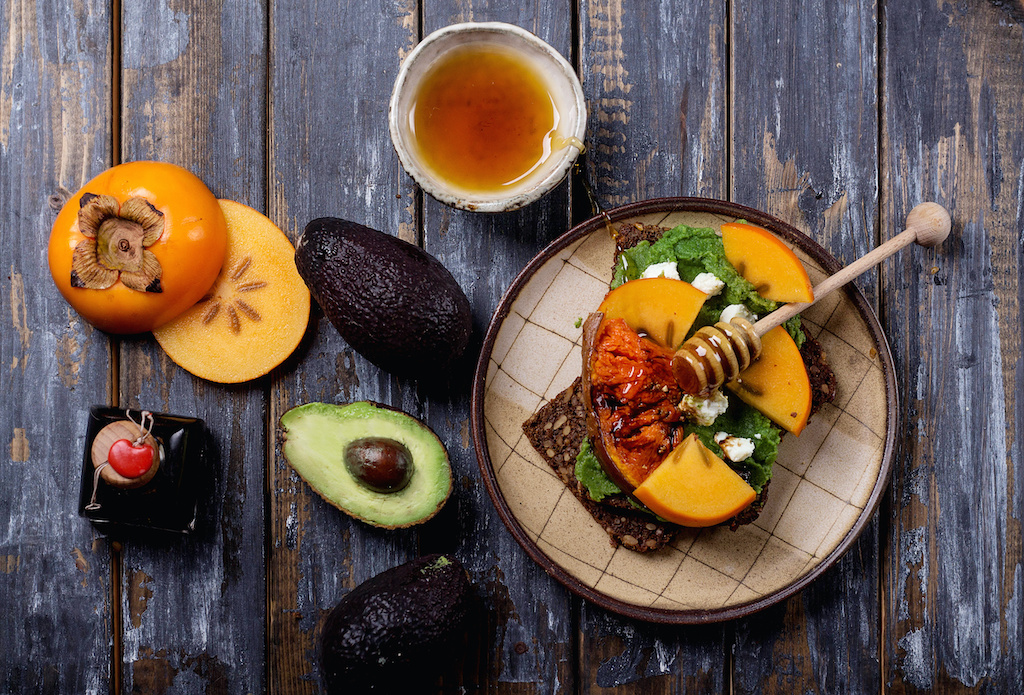 Home made vegan sandwich with avocado dip, baked pumpkin and persimmon, decorated with Feta cheese abd balsamic. Top View